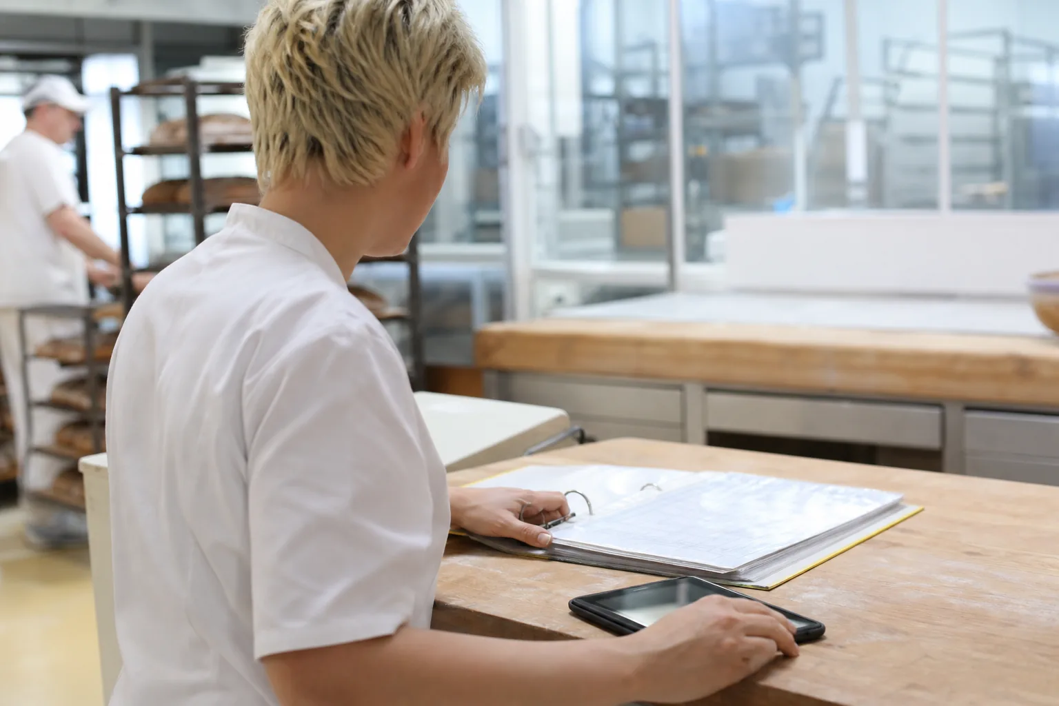 Ordner mit Hygienenachweisen und Tablet auf einem Arbeitstisch in einer Bäckerei